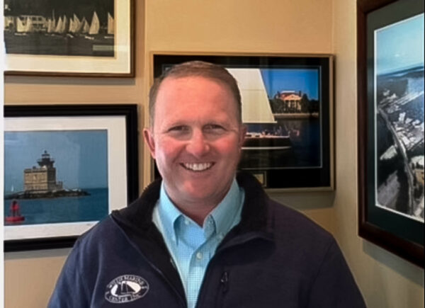 Headshot of David Willis, Certified Professional Yacht Broker at the Huntington, NY office, standing in a room with nautical-themed pictures behind him.