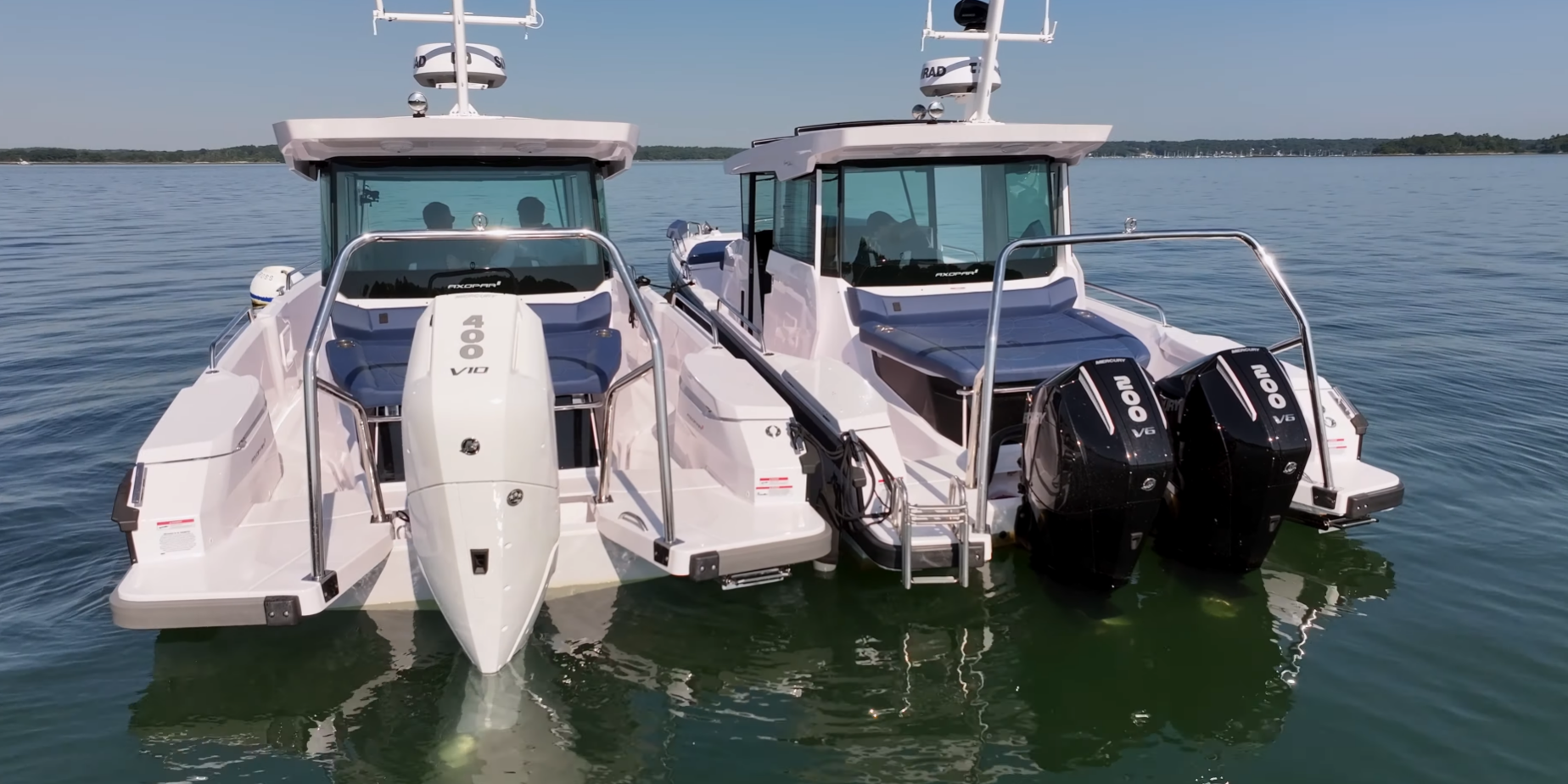 Axopar 29 Single vs Twin Engine – Stern View Stern view of two Axopar 29s floating, with a white single V10 400hp engine boat on the left and a black twin V6 200hp engine boat on the right.