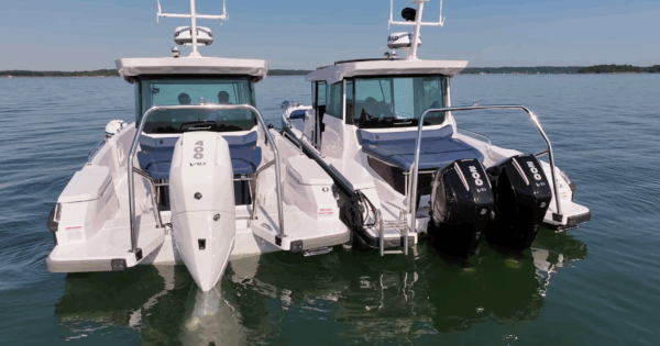 Axopar 29 Single vs Twin Engine – Stern View Stern view of two Axopar 29s floating, with a white single V10 400hp engine boat on the left and a black twin V6 200hp engine boat on the right.