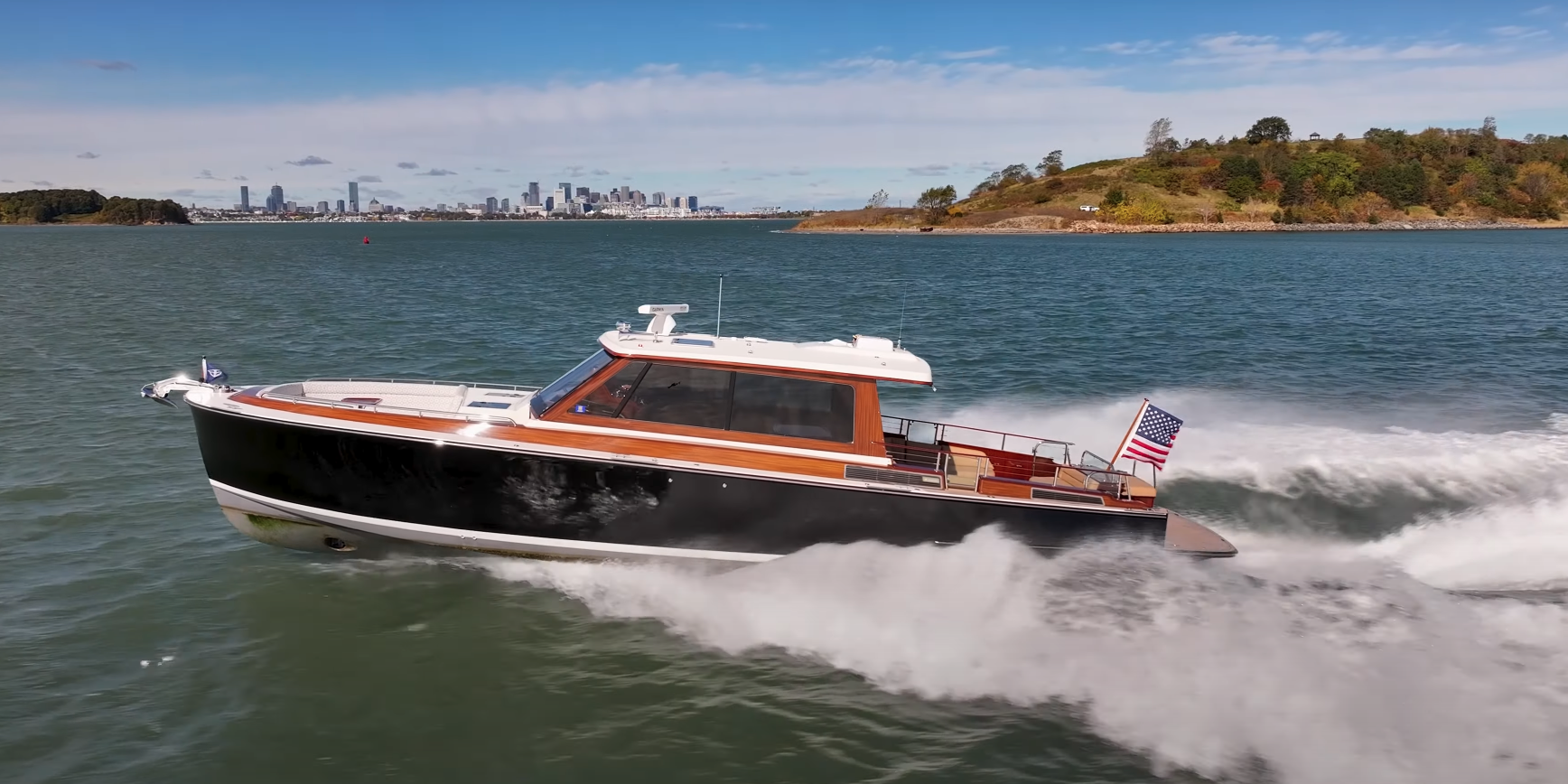 Boston Boat Works 48’ Daychaser cruising at speed with the Boston skyline visible in the distance.
