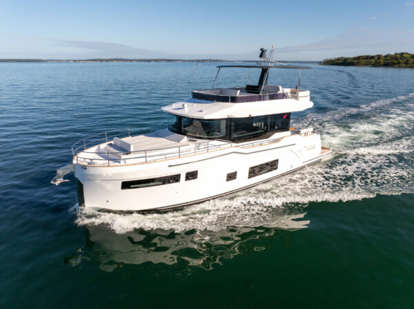 Forward port-side view of Sirena 48 flybridge cruising through green waters.