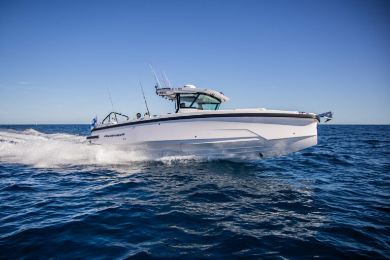 Axopar 29 CCX (Center Console) Running – Starboard Side with Finnish Flag Axopar 29 CCX (Center Console) running through deep blue ocean on starboard side with Finnish flag visible on the stern, under a clear blue sky.