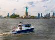 Targa 37 cruising in New York Harbor with the Statue of Liberty in the background.