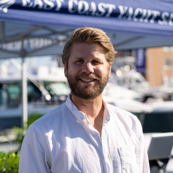 Headshot of Ben Scheffer, Yacht Consultant based in Camden, Maine, taken at the Newport International Boat Show 2025 with the East Coast Yacht Sales tent in the background.
