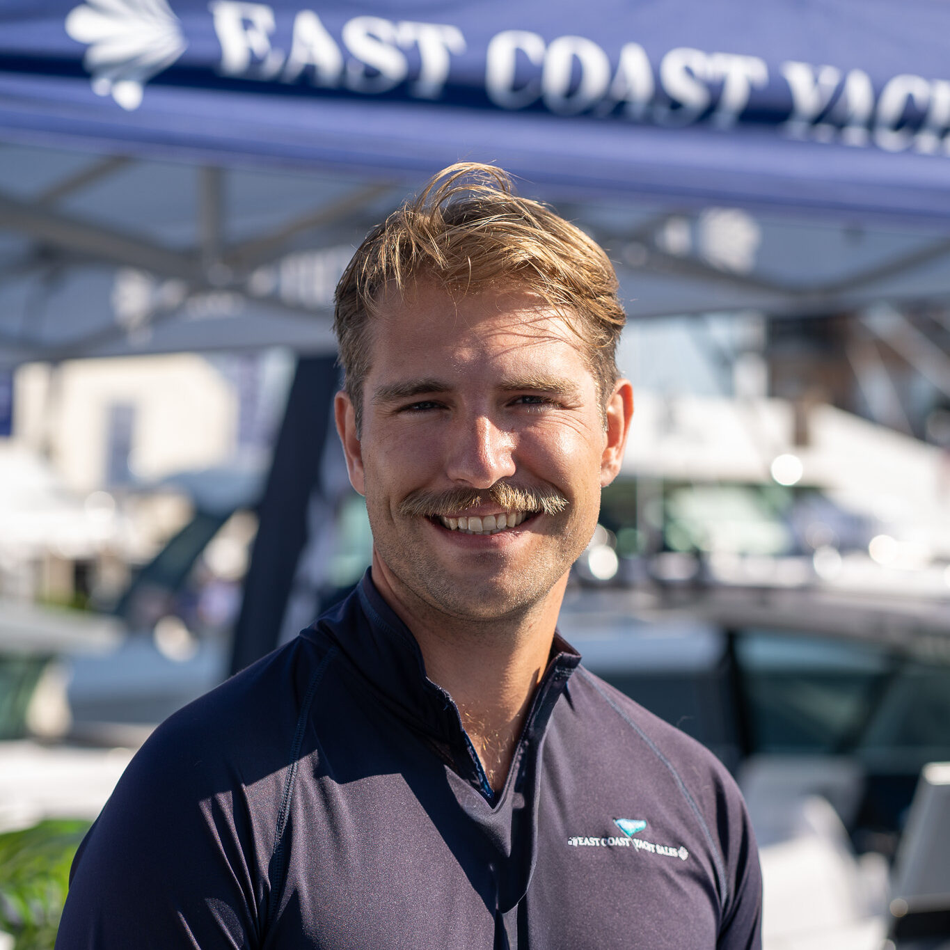 Nate Richards – Yacht Consultant, East Coast Yacht Sales, Yarmouth, ME Headshot of Nate Richards, Yacht Consultant based in Yarmouth, Maine, taken at the Newport International Boat Show 2025 with the East Coast Yacht Sales tent in the background.