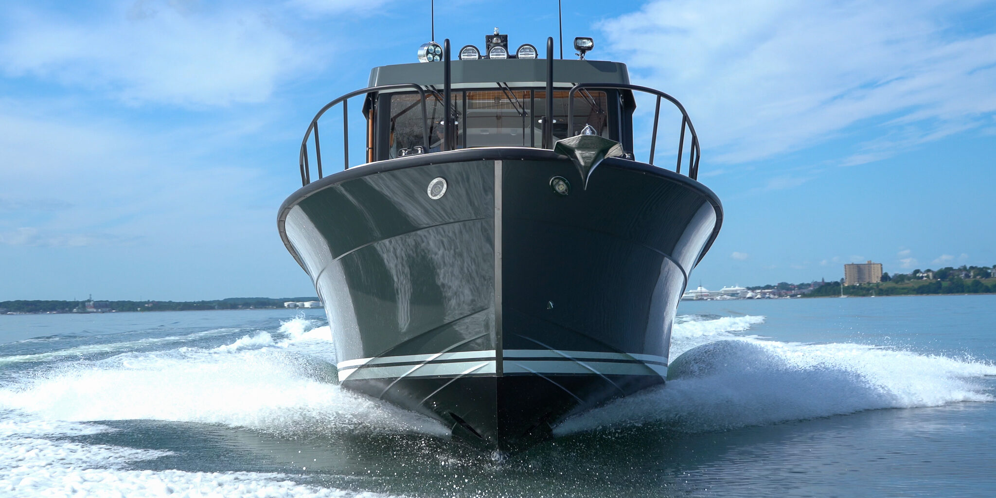 Targa 32 Cruising in Casco Bay – Portland, Maine Targa 32 with green hull cruising head-on in Casco Bay, Portland, Maine, with the Eastern Promenade visible in the distance.