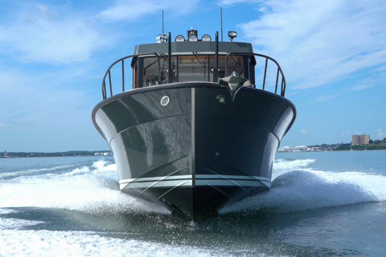 Targa 32 Cruising in Casco Bay – Portland, Maine Targa 32 with green hull cruising head-on in Casco Bay, Portland, Maine, with the Eastern Promenade visible in the distance.